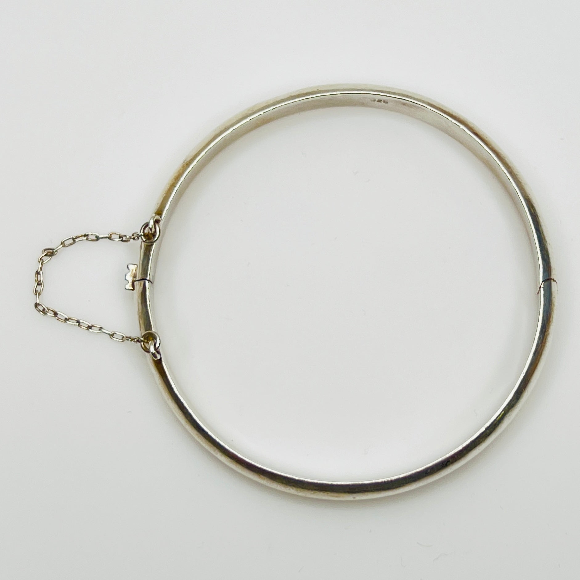 Full view of 1980s bangle with safety chain, laying flat