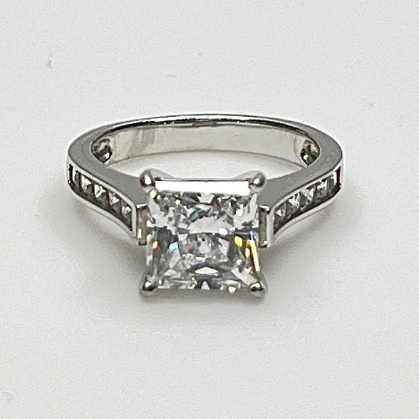 CZ ring with a square-cut gemstone on a light gray background