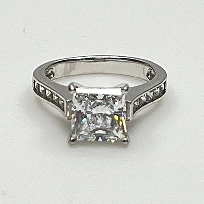 CZ ring with a square-cut gemstone on a light gray background