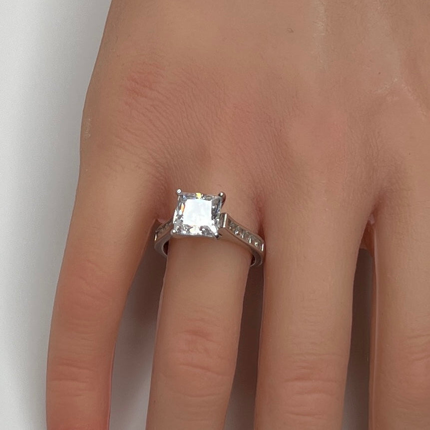 Sterling silver bridal set on model hand with princess-cut solitaire