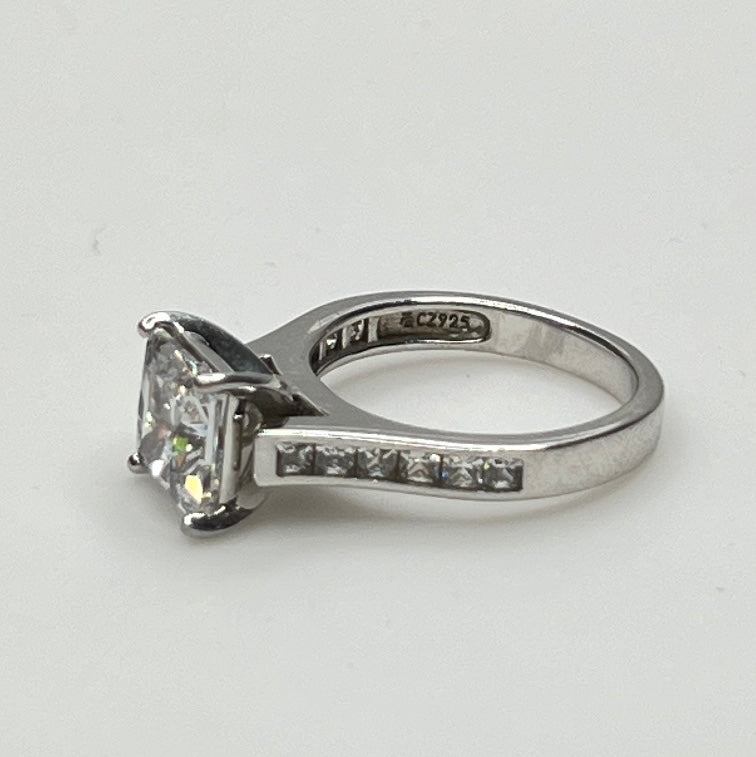 CZ ring with a square-cut gemstone on a light gray background