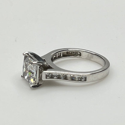 CZ ring with a square-cut gemstone on a light gray background