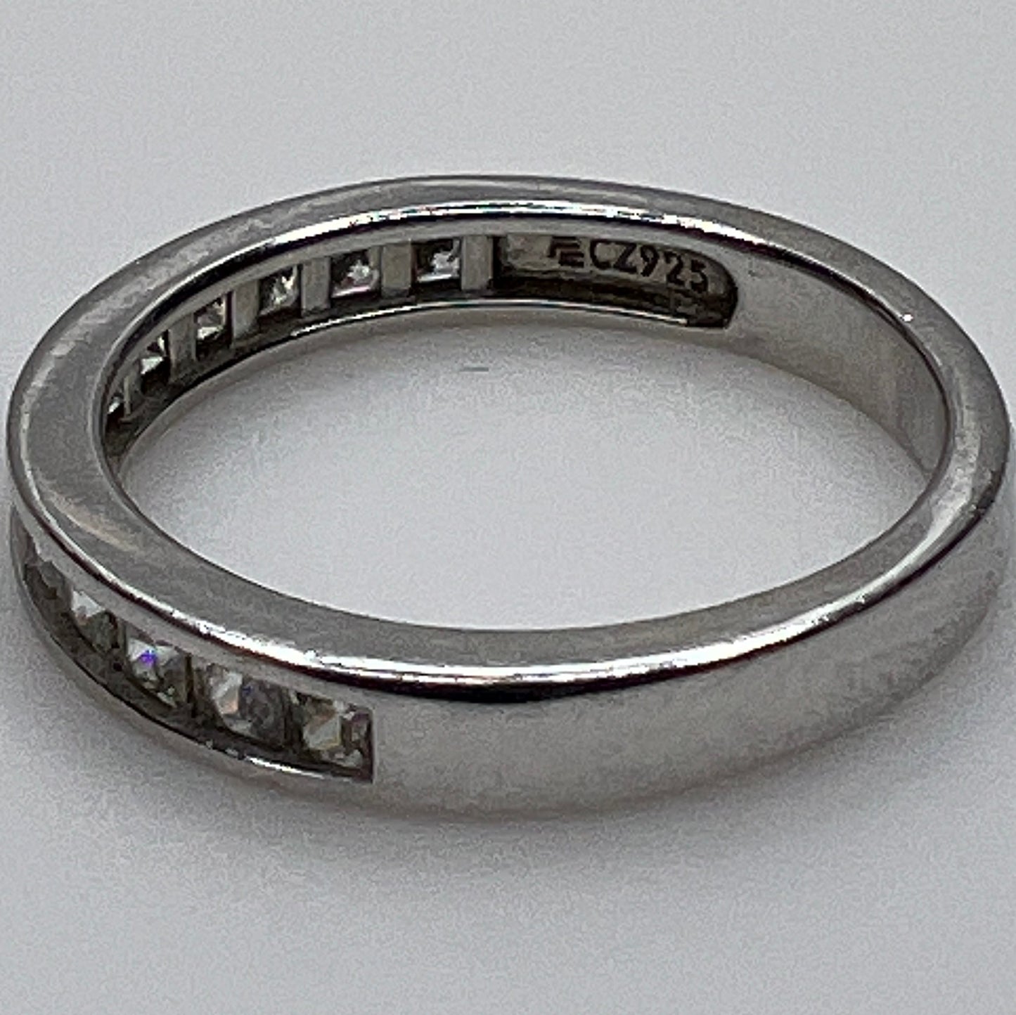 Silver ring with embedded cubic Zirconia on a light gray background
