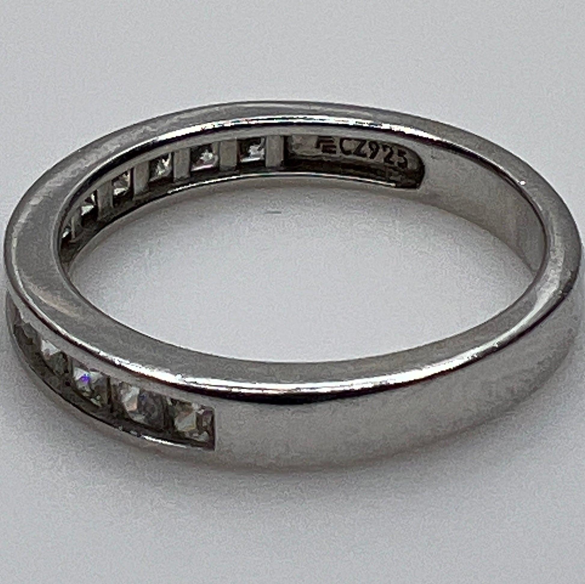 Silver ring with embedded cubic Zirconia on a light gray background