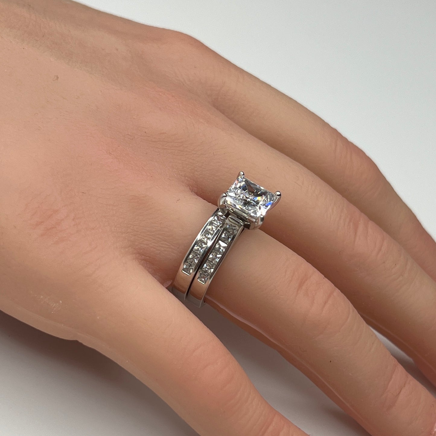 Sterling silver bridal set on model hand with princess-cut solitaire