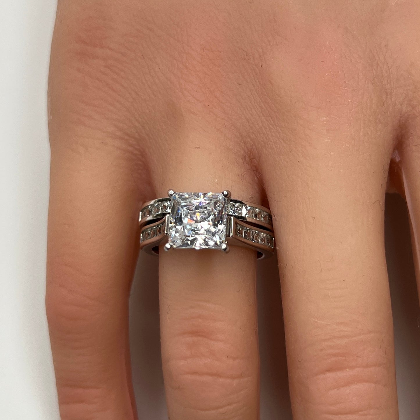 Sterling silver bridal set on model hand with princess-cut solitaire