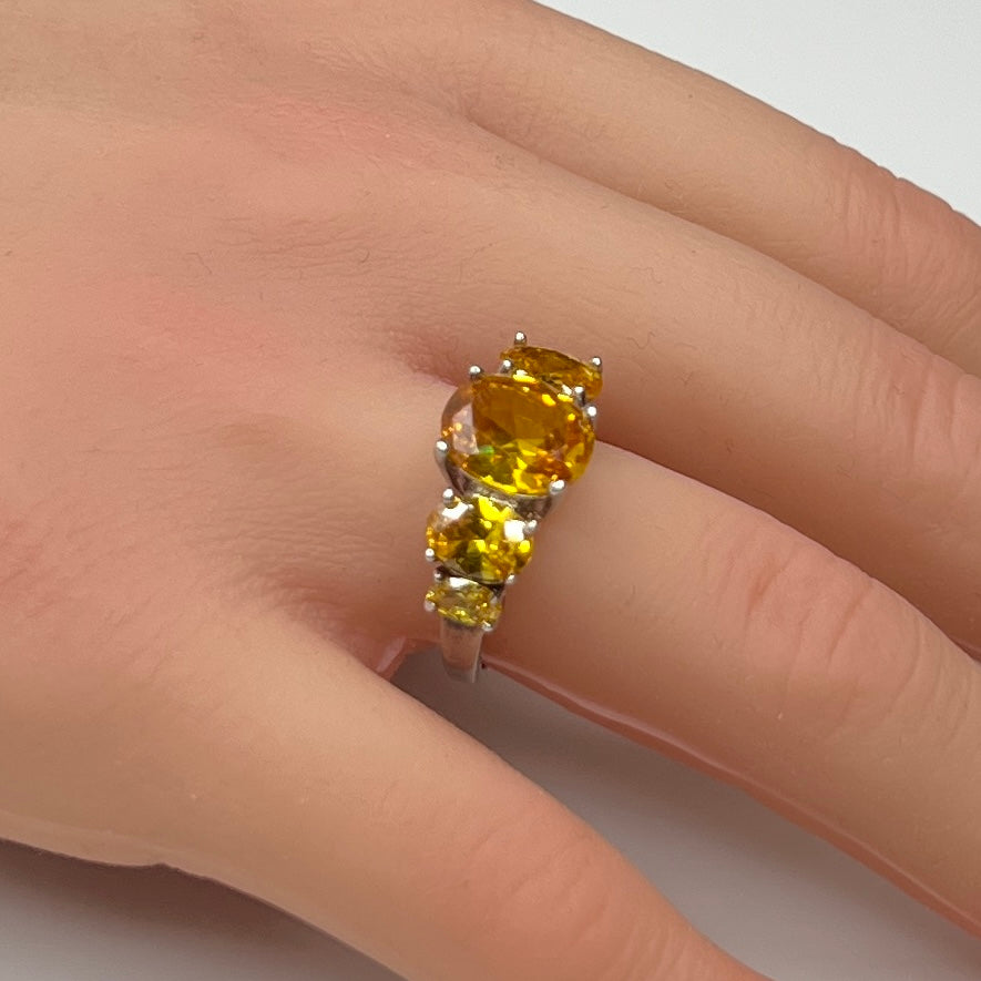 Sterling silver citrine ring worn on a hand, showing five faceted oval stones