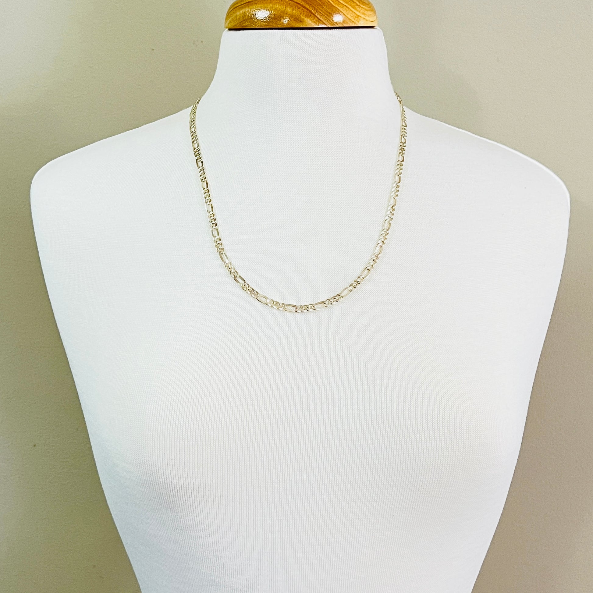 1980s vintage silver Figaro chain displayed on mannequin bust