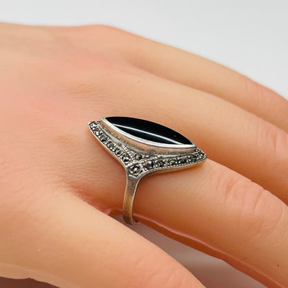 Sterling silver black onyx and marcasite ring worn on hand, marquise shape
