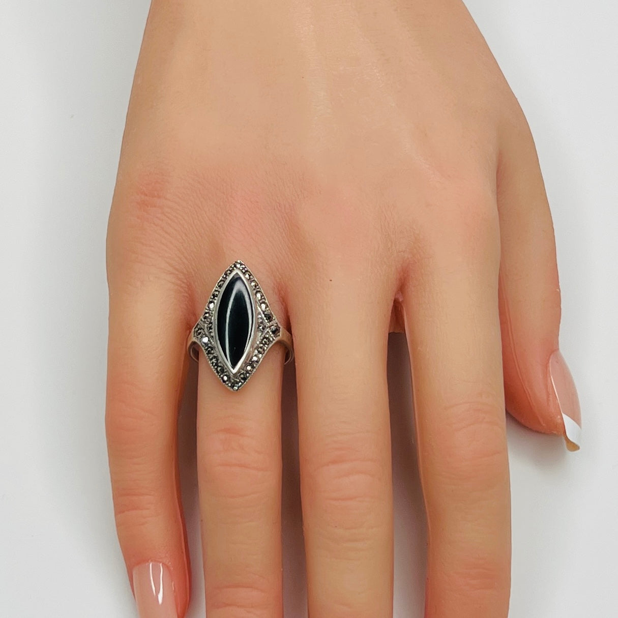 Sterling silver black onyx and marcasite ring worn on hand, marquise shape