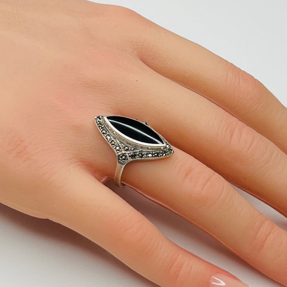 Sterling silver black onyx and marcasite ring worn on hand, marquise shape
