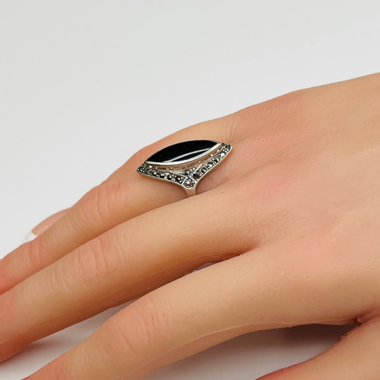 Sterling silver black onyx and marcasite ring worn on hand, marquise shape