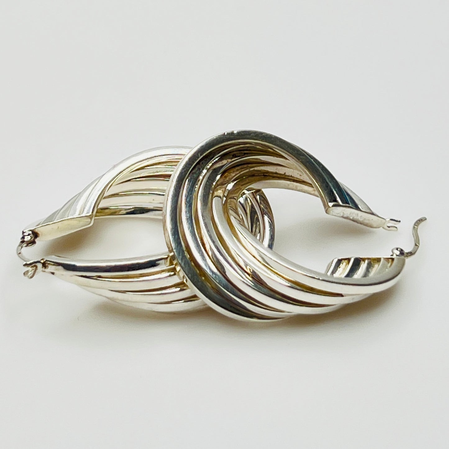 Sculptural ridged silver hoops with fluid layered design