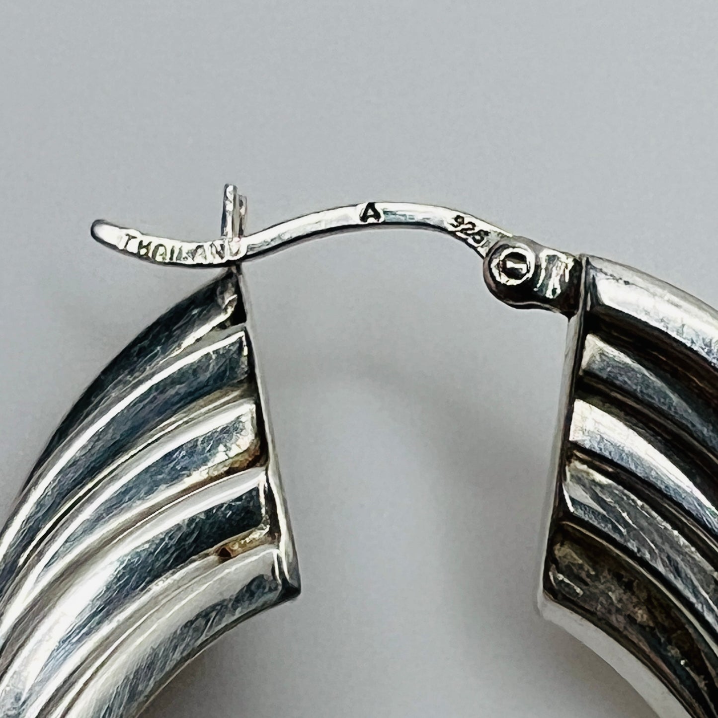 Close-up of ear wire stamped Thailand and 925 on sterling earrings