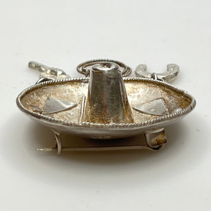 Vintage sombrero hat brooch in silver showing 3D brim and charm depth – angled view