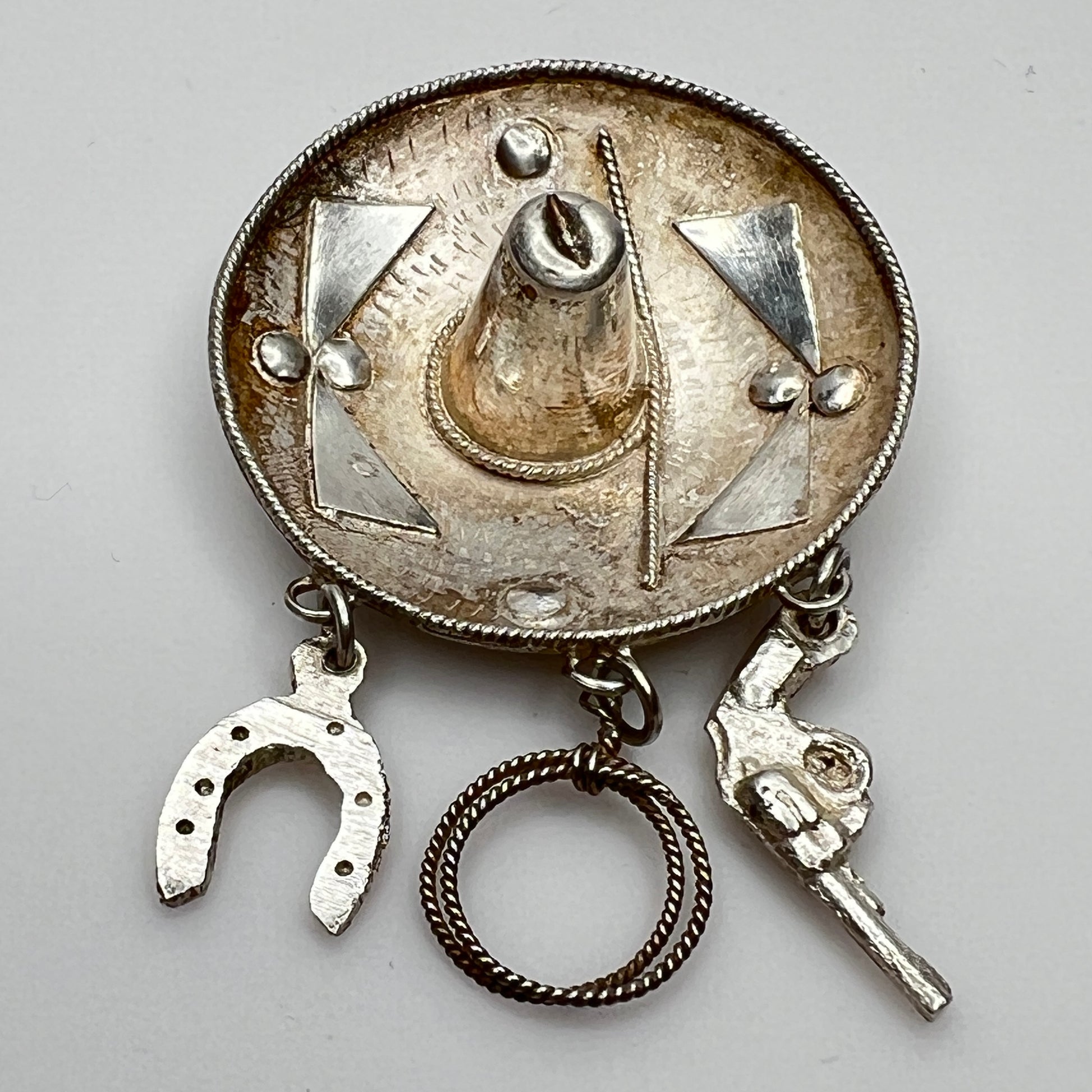 Vintage sombrero hat brooch in silver showing 3D brim and charm depth – angled view