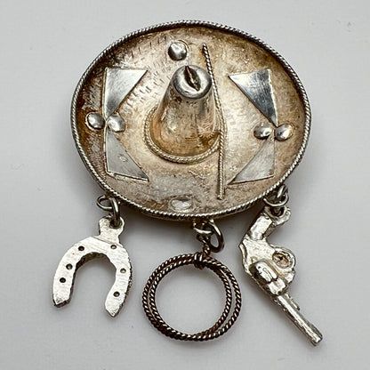 Vintage sombrero hat brooch in silver showing 3D brim and charm depth – angled view