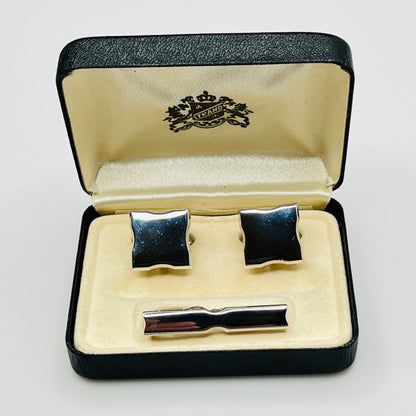 Cufflinks and tie clip set in a branded box on a light gray background