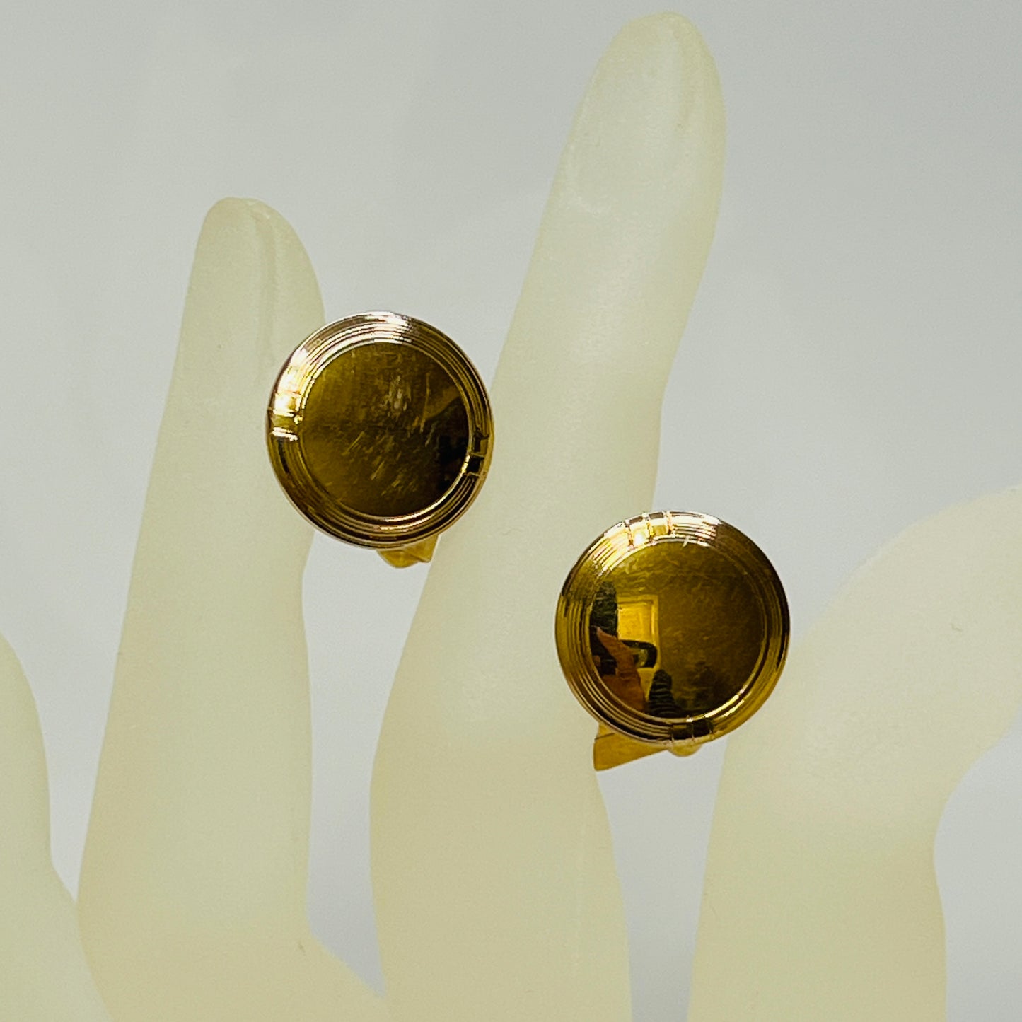 Close-up of circular cufflink detail with subtle wear