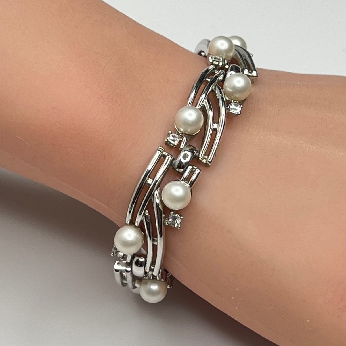 Trifari silver-tone bracelet with faux pearls and rhinestones worn on wrist