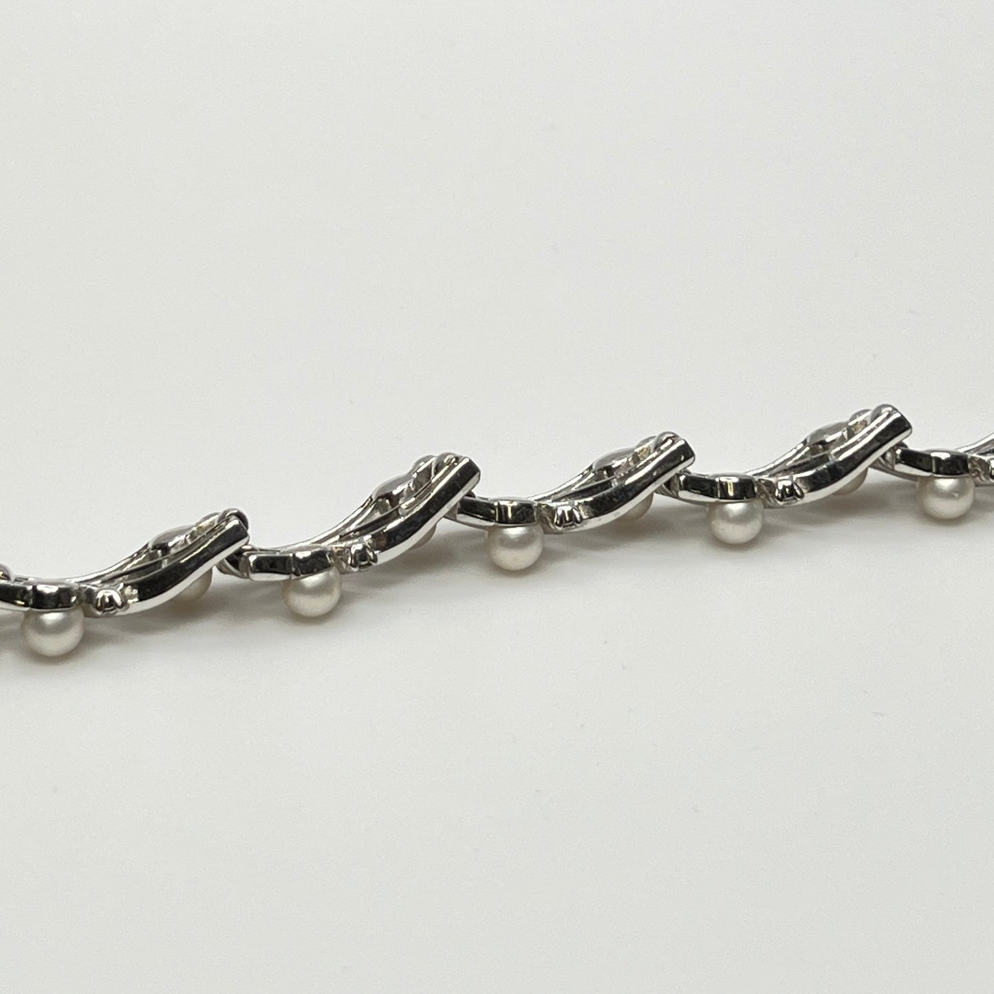 Trifari vintage bracelet with wavy silver panels and pearls laid flat