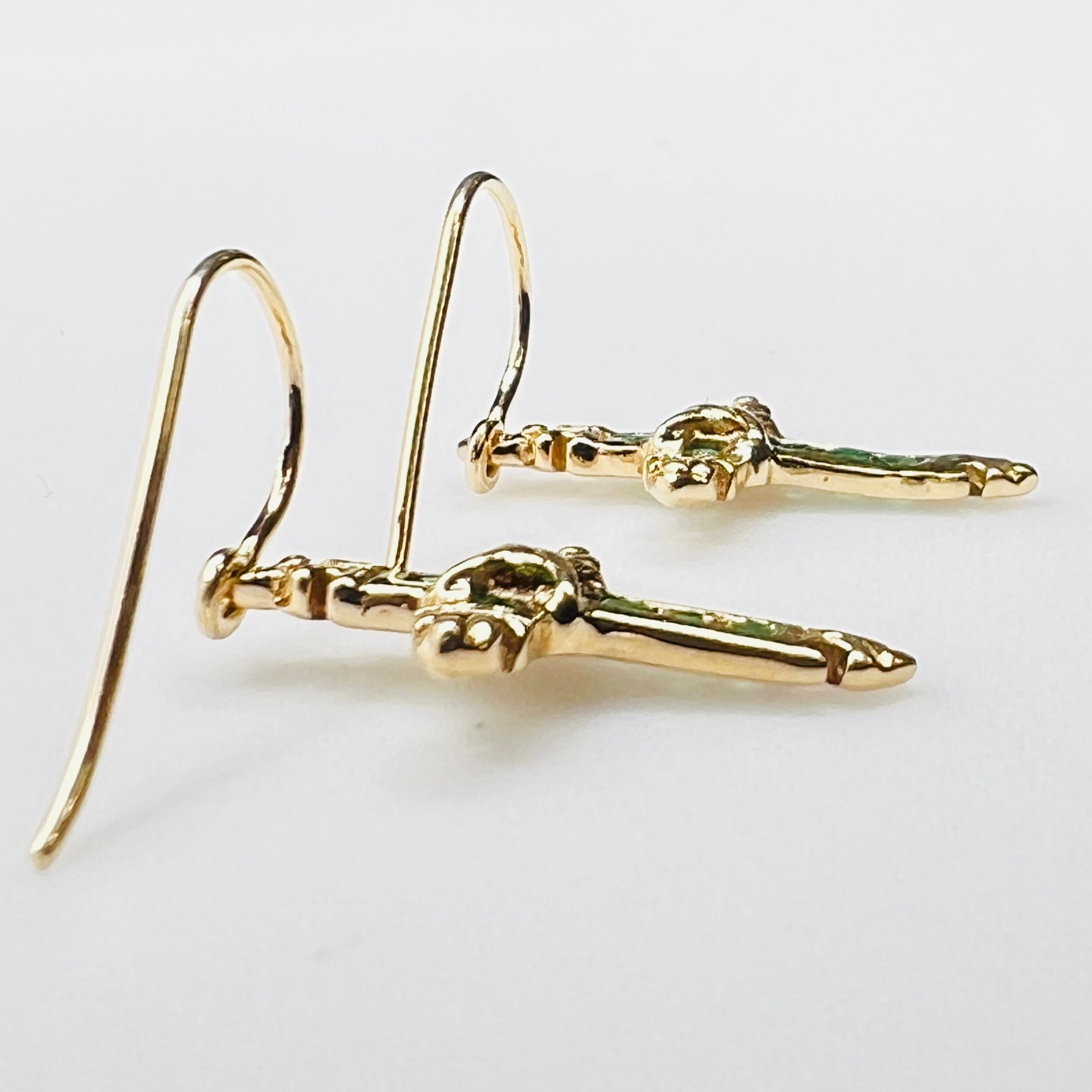 Close up of emerald gemstone cross earrings