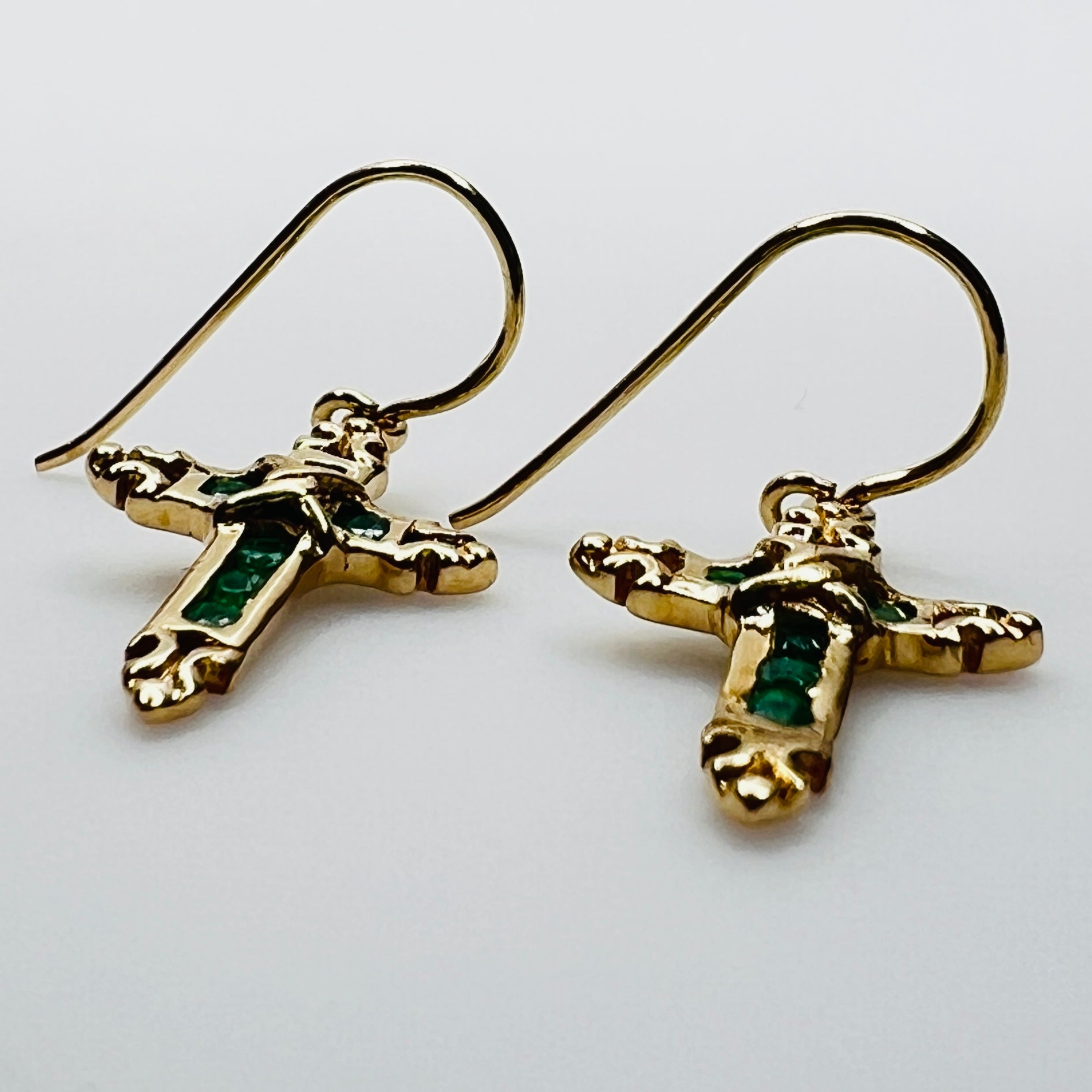 Close up of emerald gemstone cross earrings