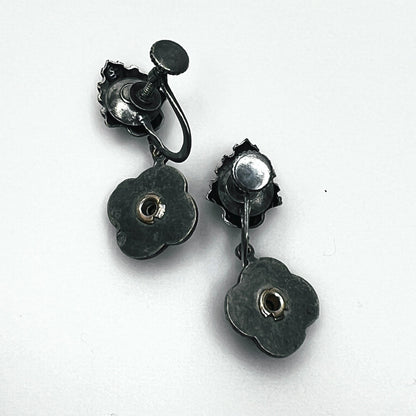 Reverse of vintage screw-back floral earrings showing adjustable screw fittings and metal construction.