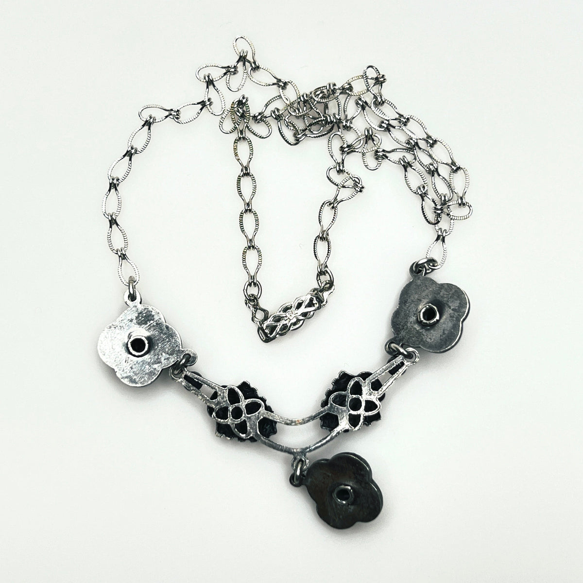Reverse of vintage Art Nouveau Revival necklace showing openwork construction, chain and decorative hook clasp.