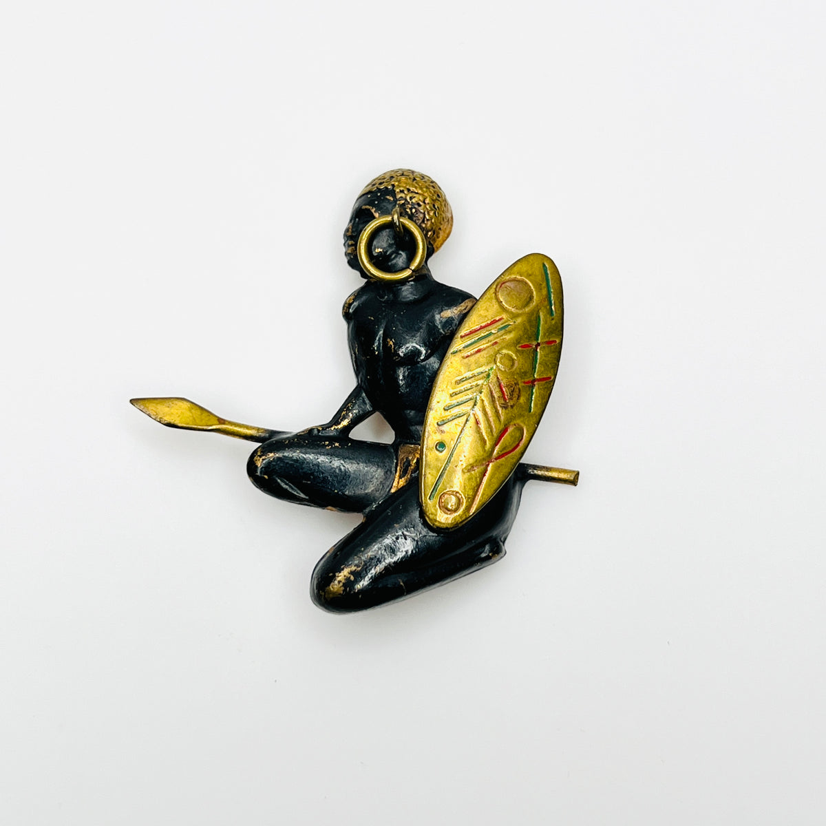 Vintage mid-century African hunter figural brooch with black finish, gold shield, spear, and movable hoop earring.