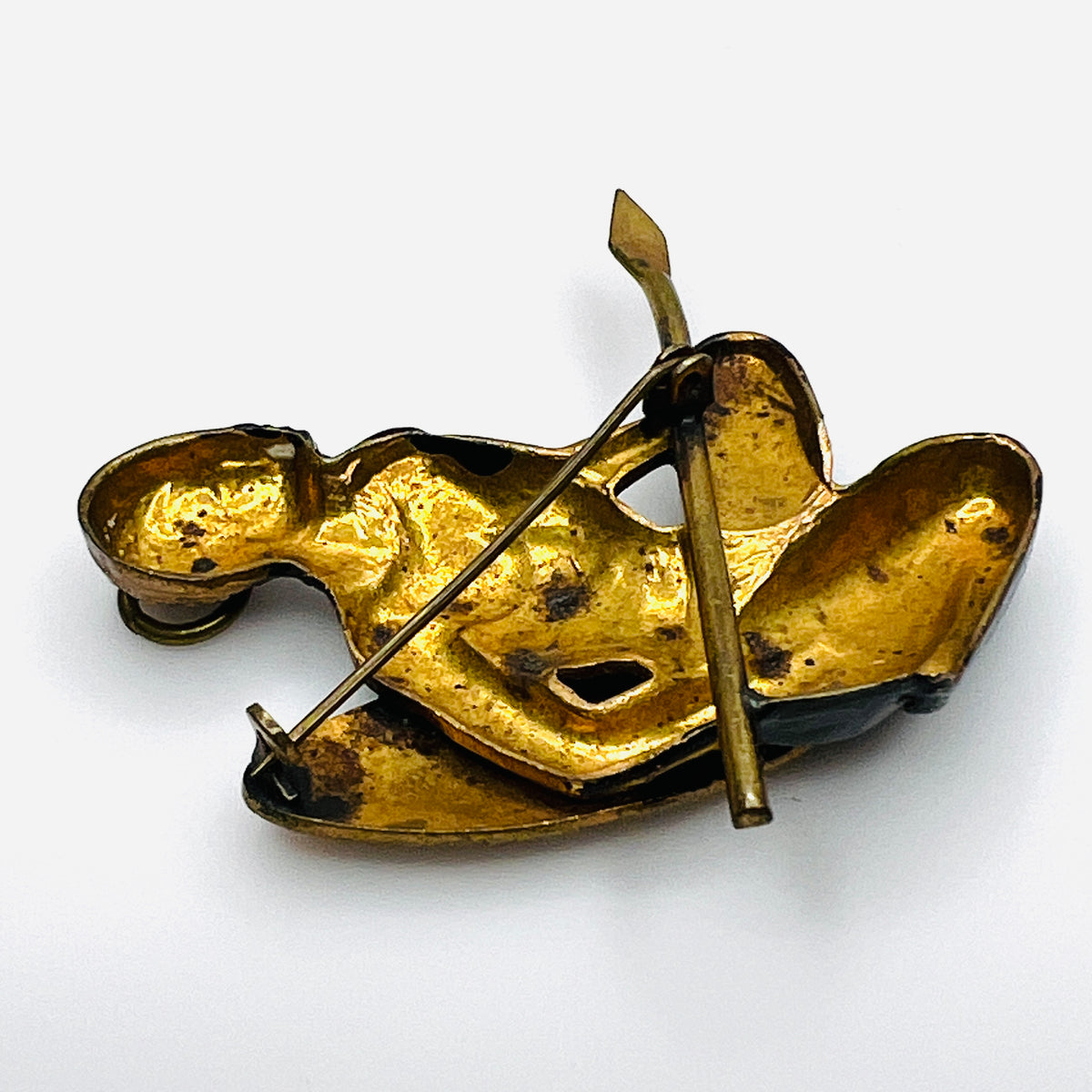Reverse of vintage African hunter brooch showing gold-tone cast-metal construction and C-clasp fastening.