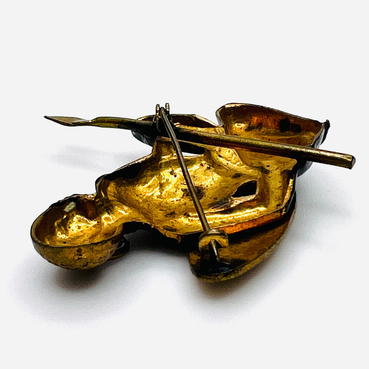 Reverse of vintage African hunter brooch showing gold-tone cast-metal construction and C-clasp fastening.