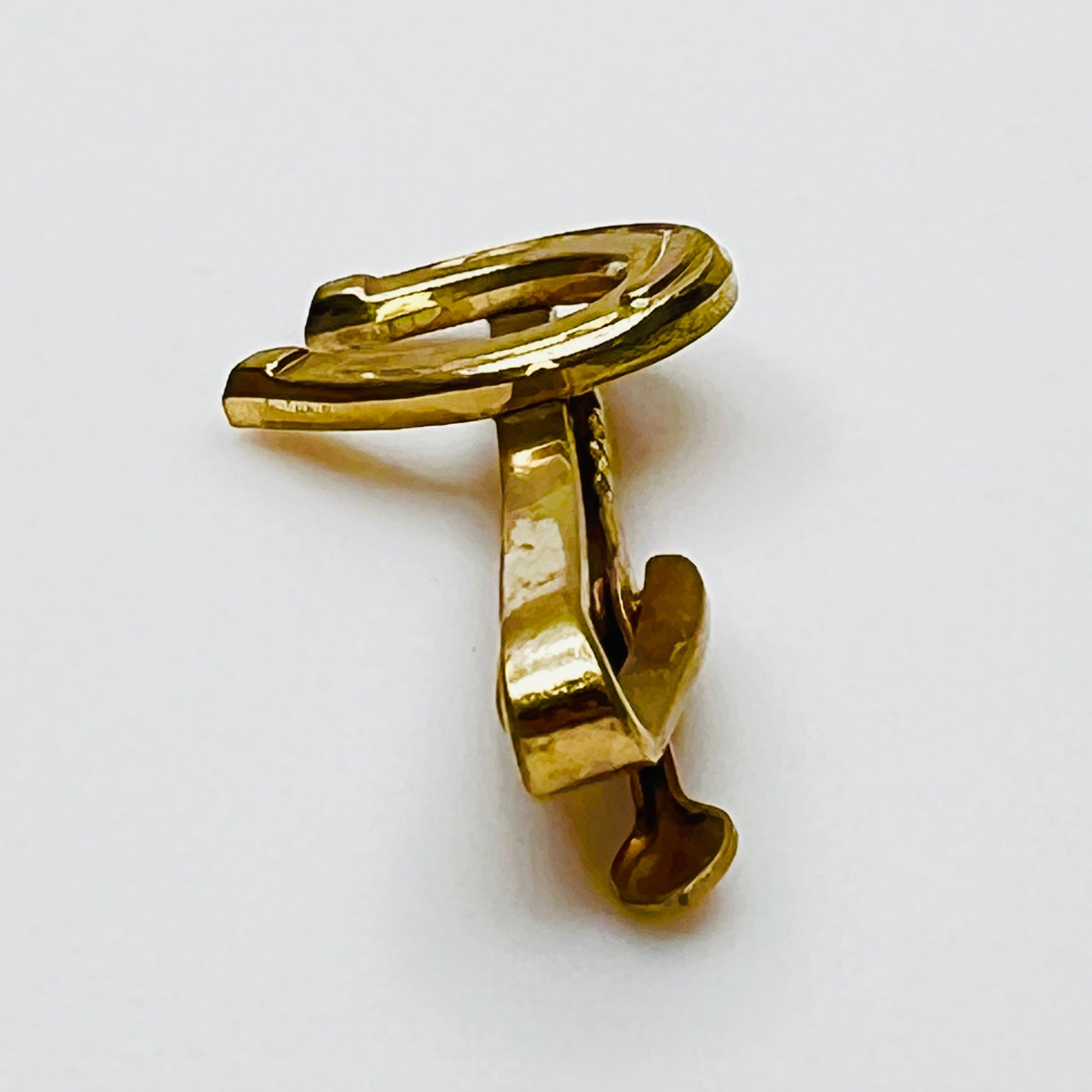 Side profile of vintage gold tone Hickok tie clip with horseshoe design
