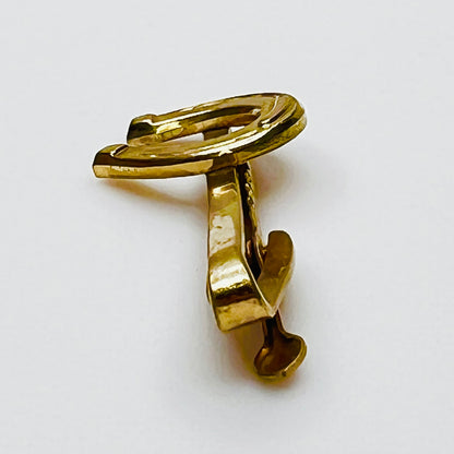 Side profile of vintage gold tone Hickok tie clip with horseshoe design