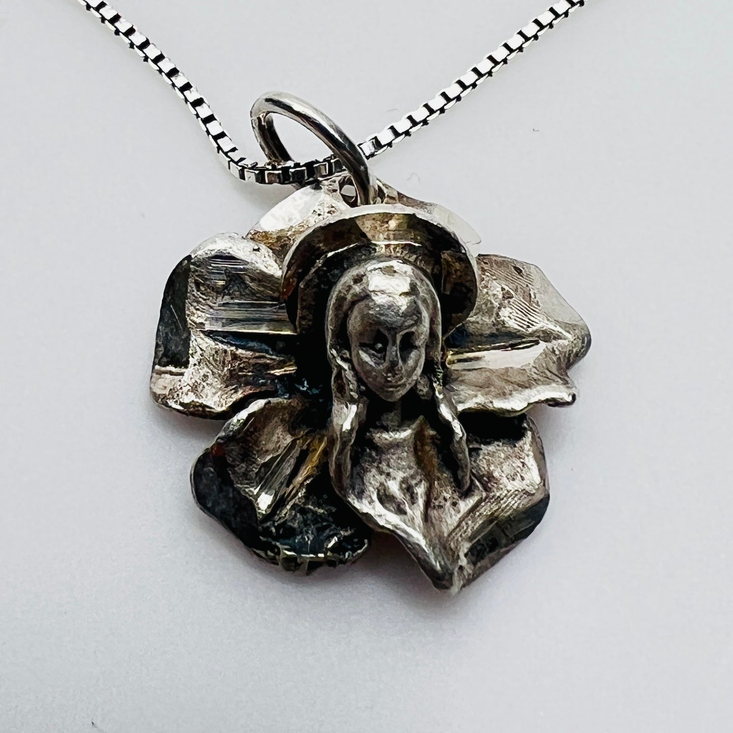 Close-up of vintage Madonna flower pendant in sterling silver