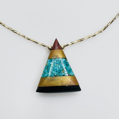 Close-up turquoise chip inlay geometric pendant gold accents
