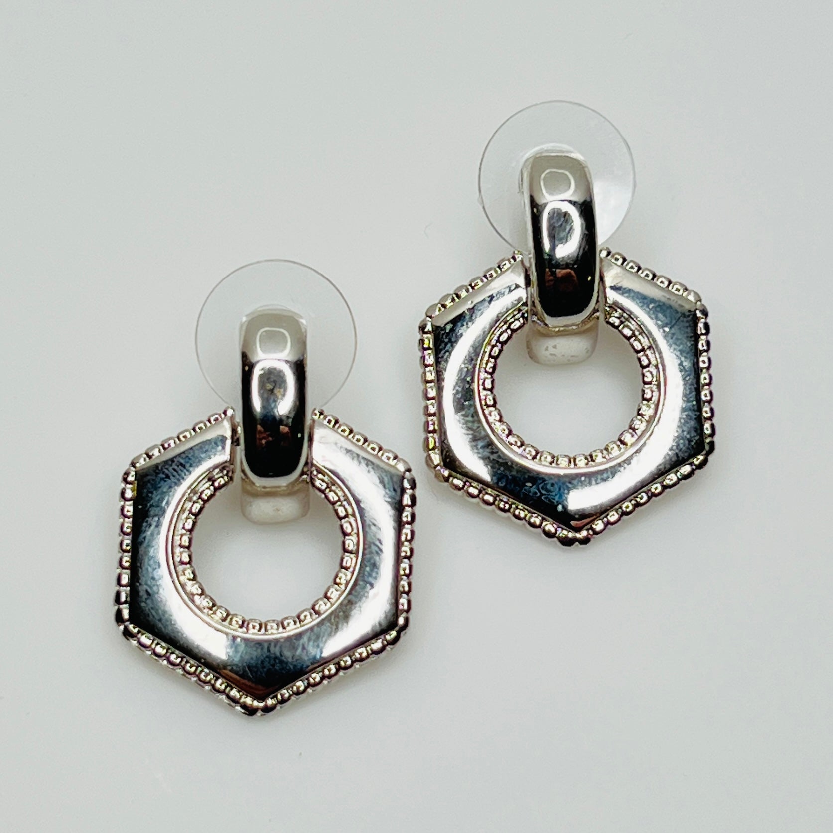 Close-up of earrings showing silver finish and 14K gold post with stabilizer backs