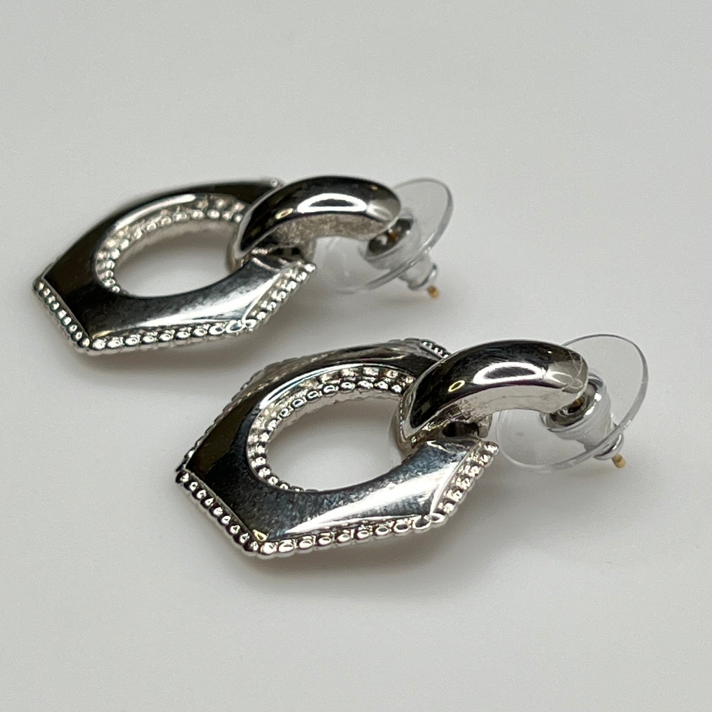 Close-up of earrings showing silver finish and 14K gold post with stabilizer backs