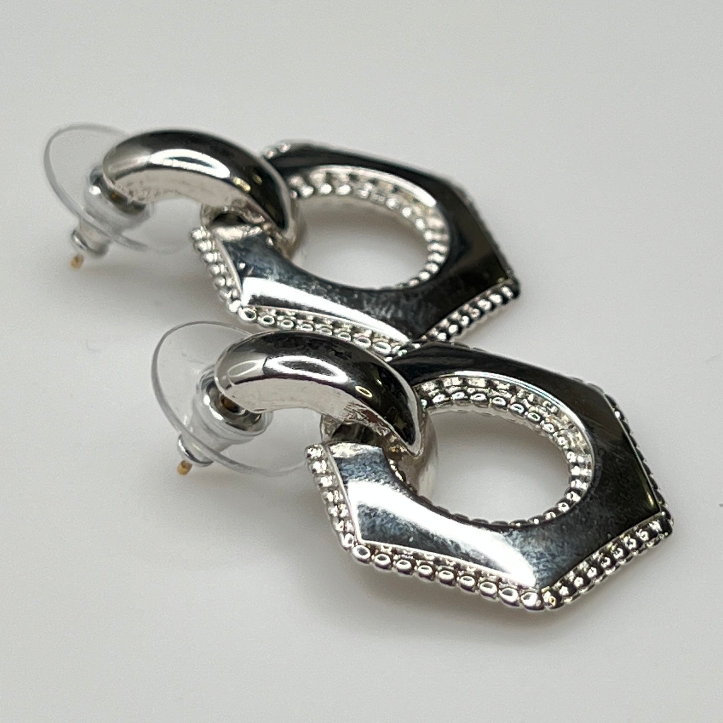 Close-up of earrings showing silver finish and 14K gold post with stabilizer backs