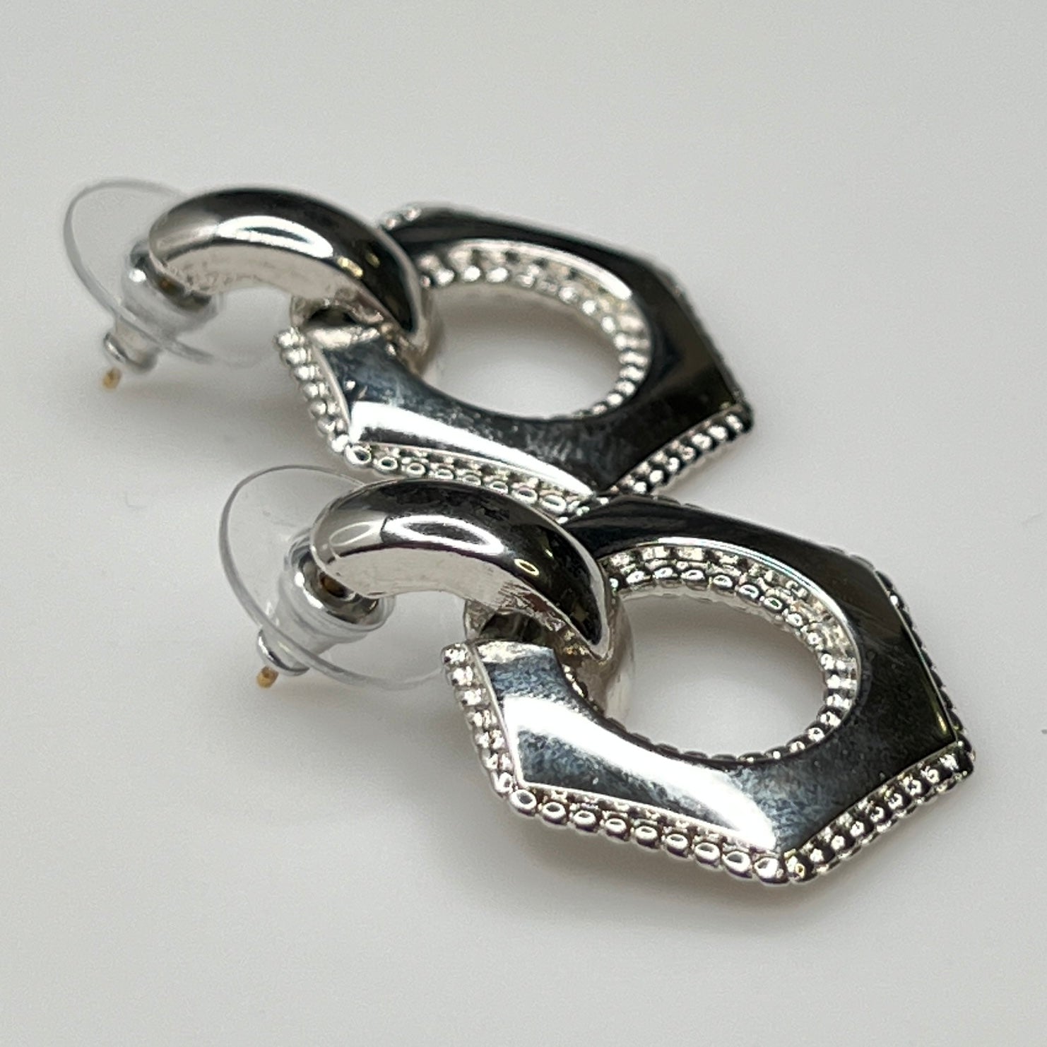 Close-up of earrings showing silver finish and 14K gold post with stabilizer backs