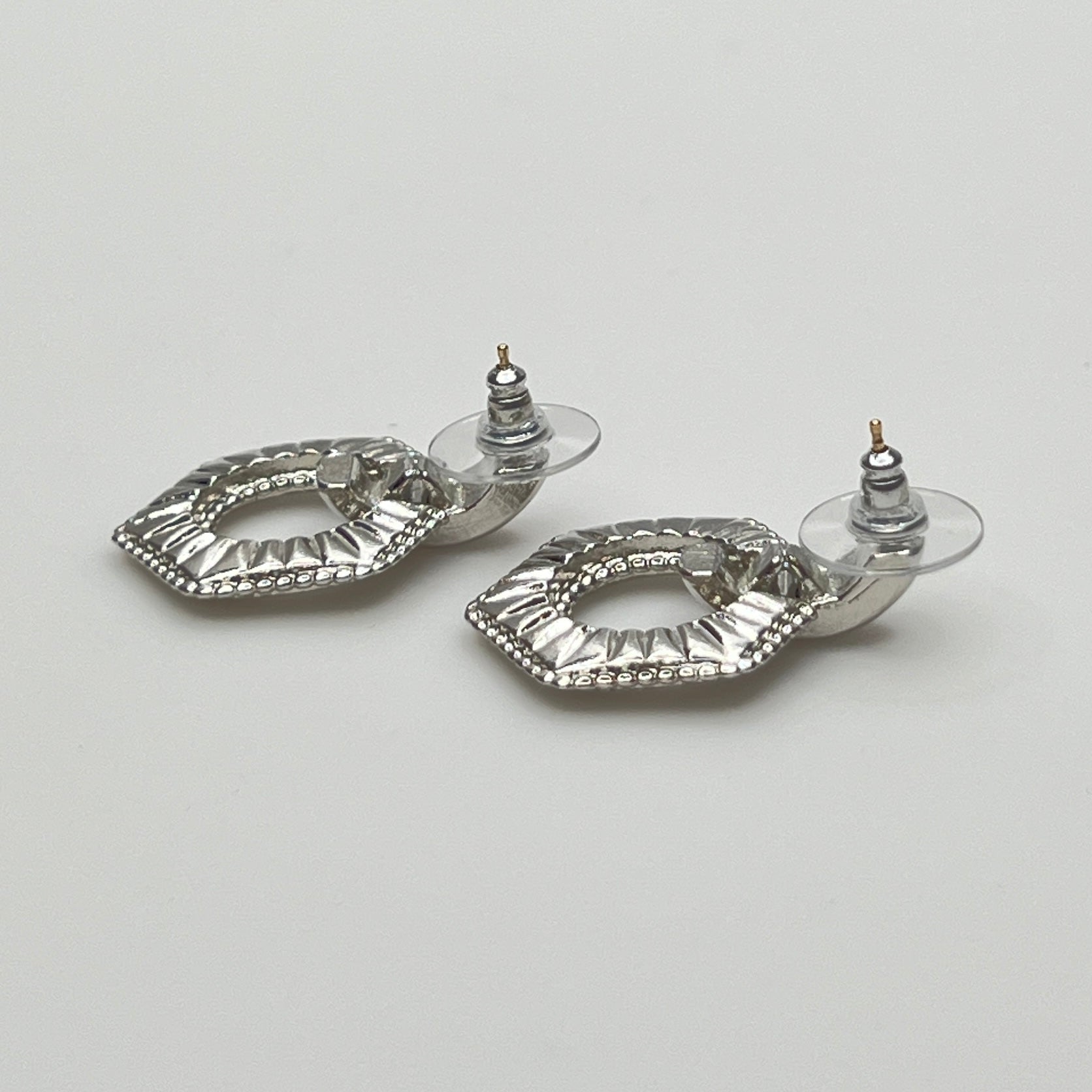 Close-up of earrings showing silver finish and 14K gold post with stabilizer backs