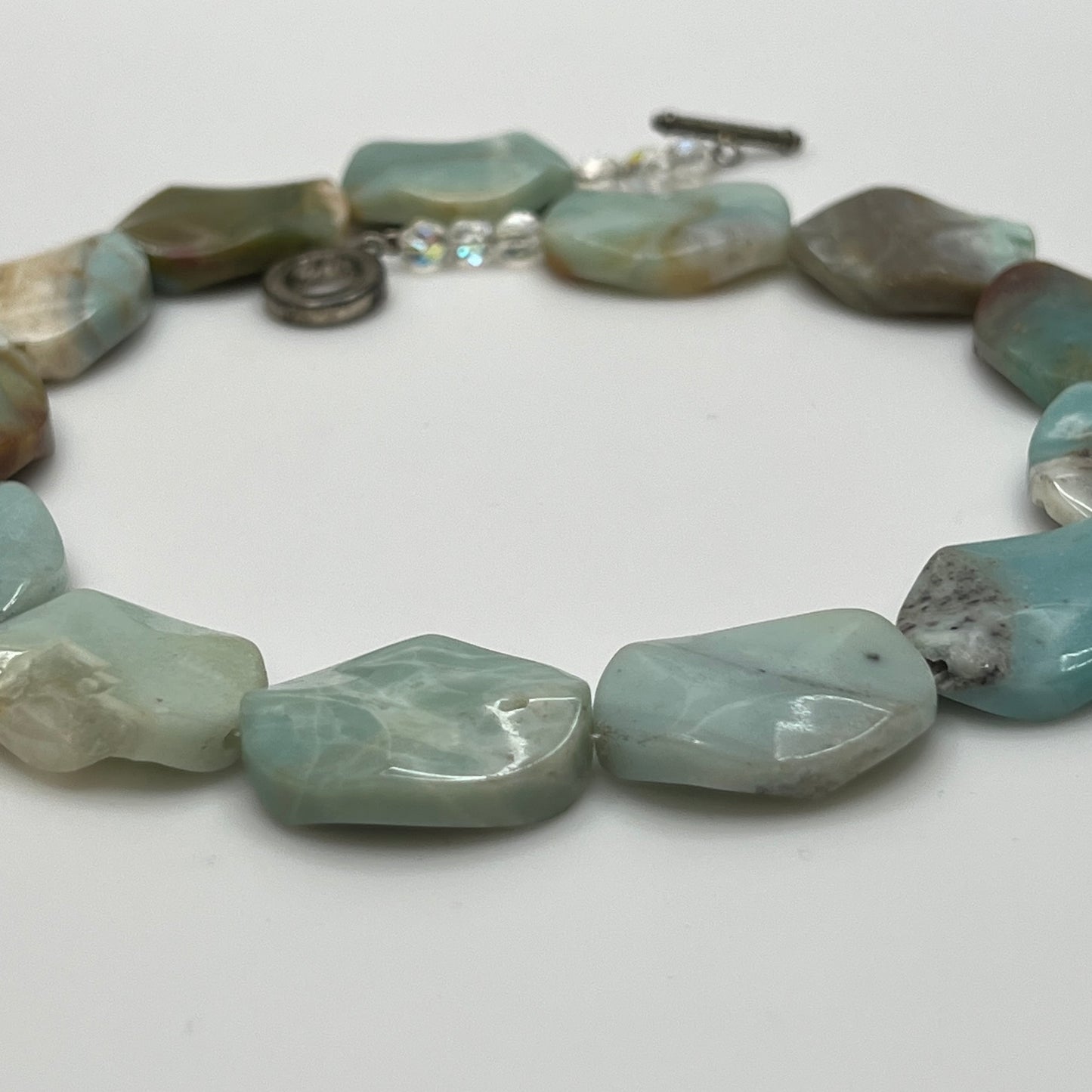 Close-up of pale blue-green amazonite beads with natural marbling