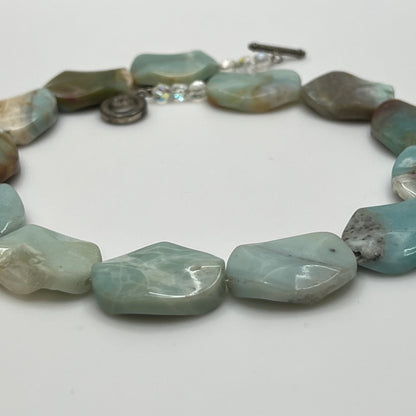 Close-up of pale blue-green amazonite beads with natural marbling