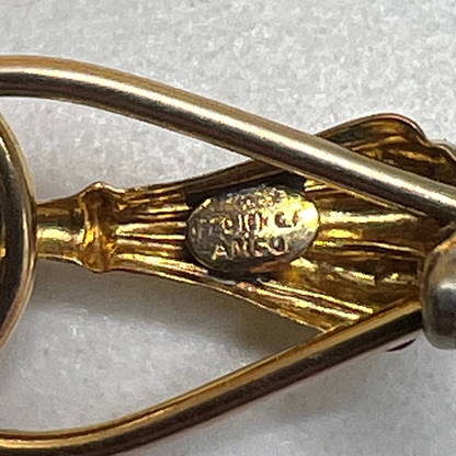 Close-up of signed AMCO bar pin with botanical styling in gold-tone