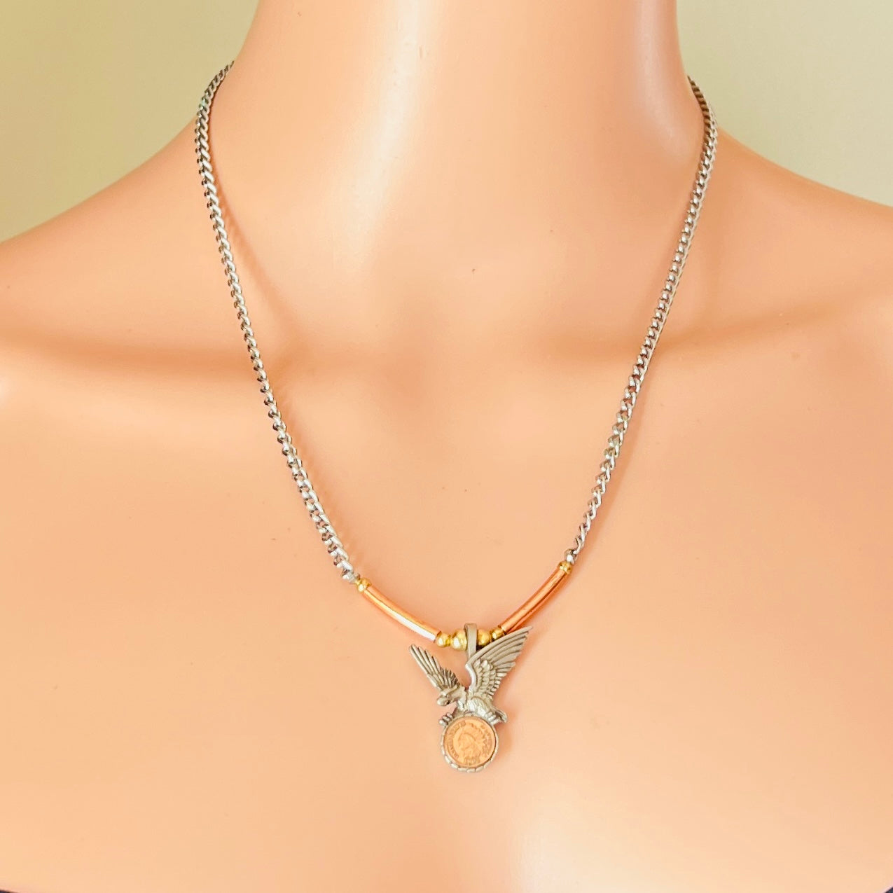 Eagle pendant necklace worn on neckline, mixed metal tones