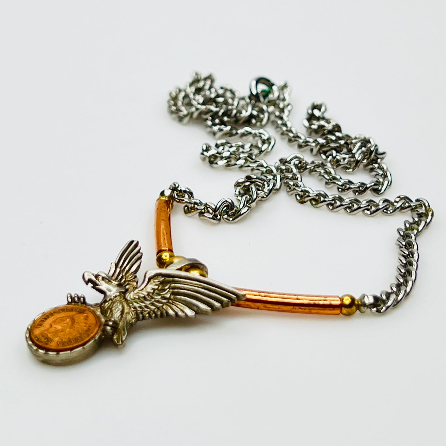 Side view of eagle pendant with copper tube accents on chain