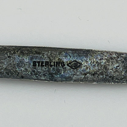 Close-up of “STERLING” stamp with maker’s mark on reverse