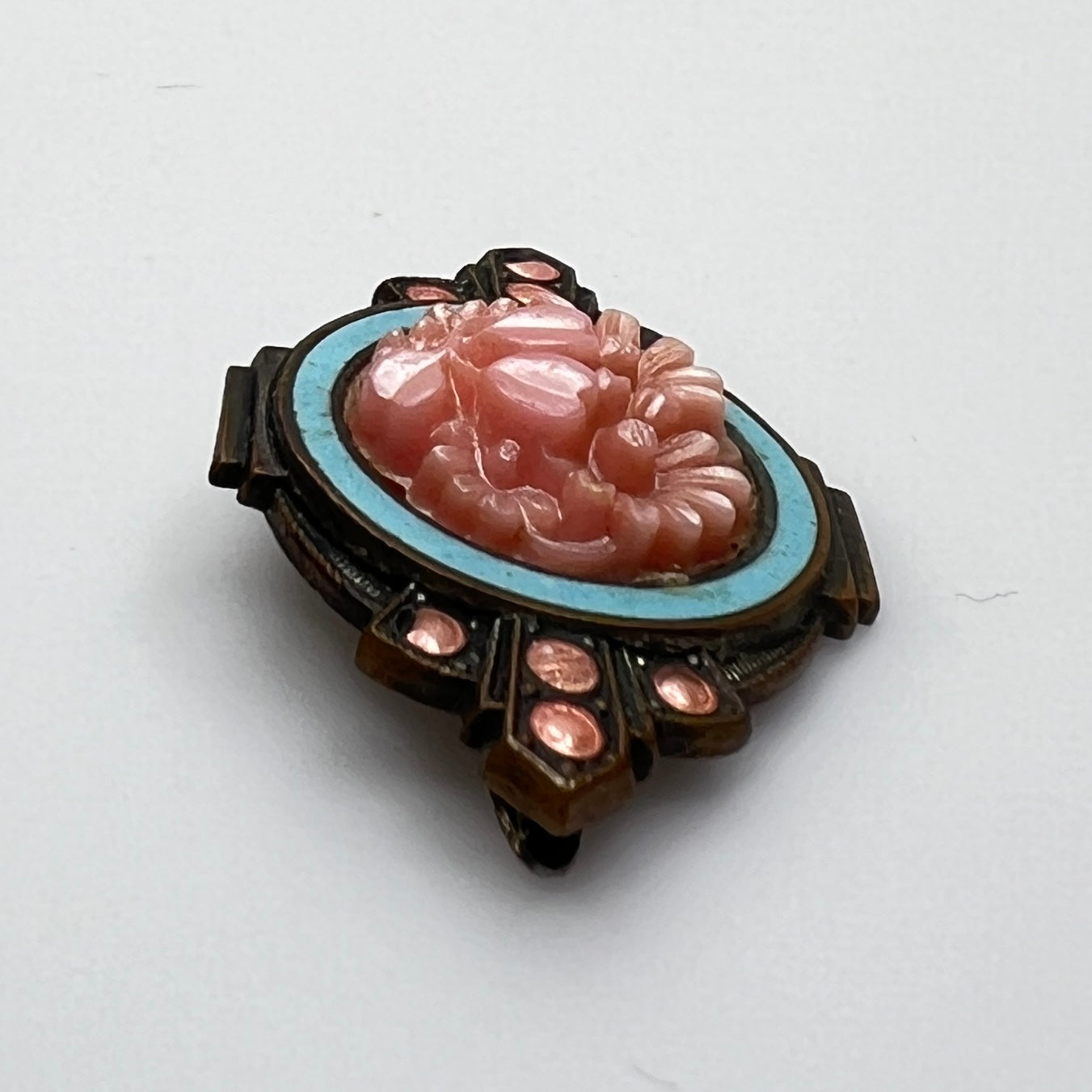 Side profile of Victorian enamel brooch with molded floral centerpiece