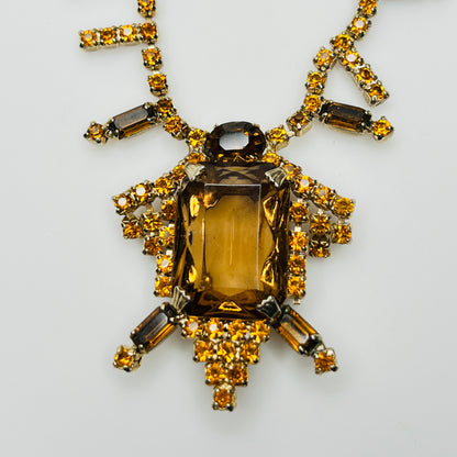 Close-up of emerald cut amber glass center stone with rhinestones
