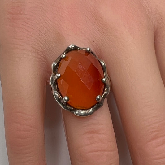 Vintage sterling silver ring with faceted oval orange carnelian in sculptural bezel setting